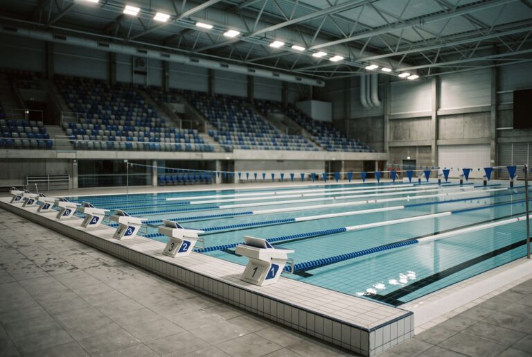 An empty indoor competition swimming pool with marked lanes