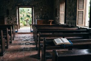Empty pews in a quiet church interior lit by afternoon light