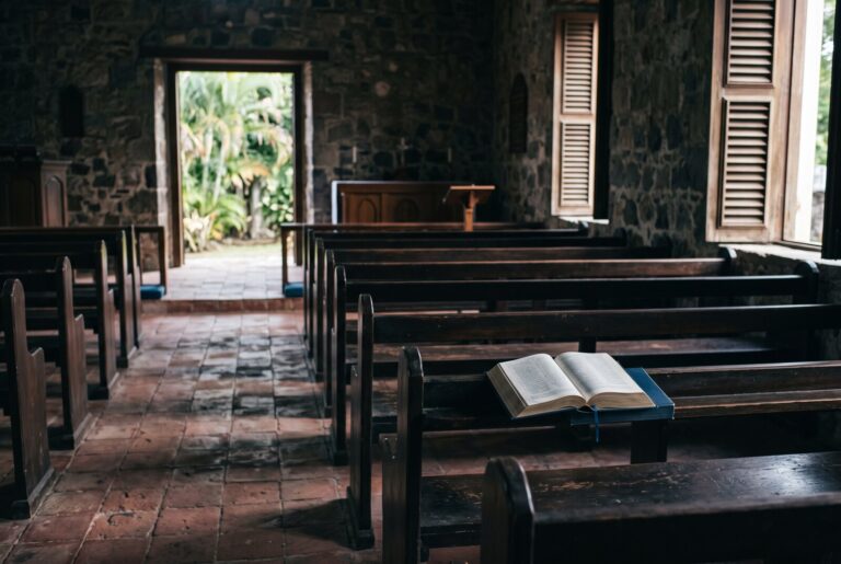 Empty pews in a quiet church interior lit by afternoon light